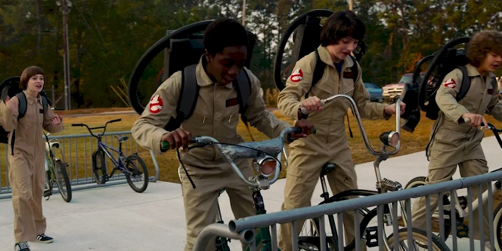 Четверо друзей в костюмах Охотников за привидениями забирают свои велосипеды со школьной парковки